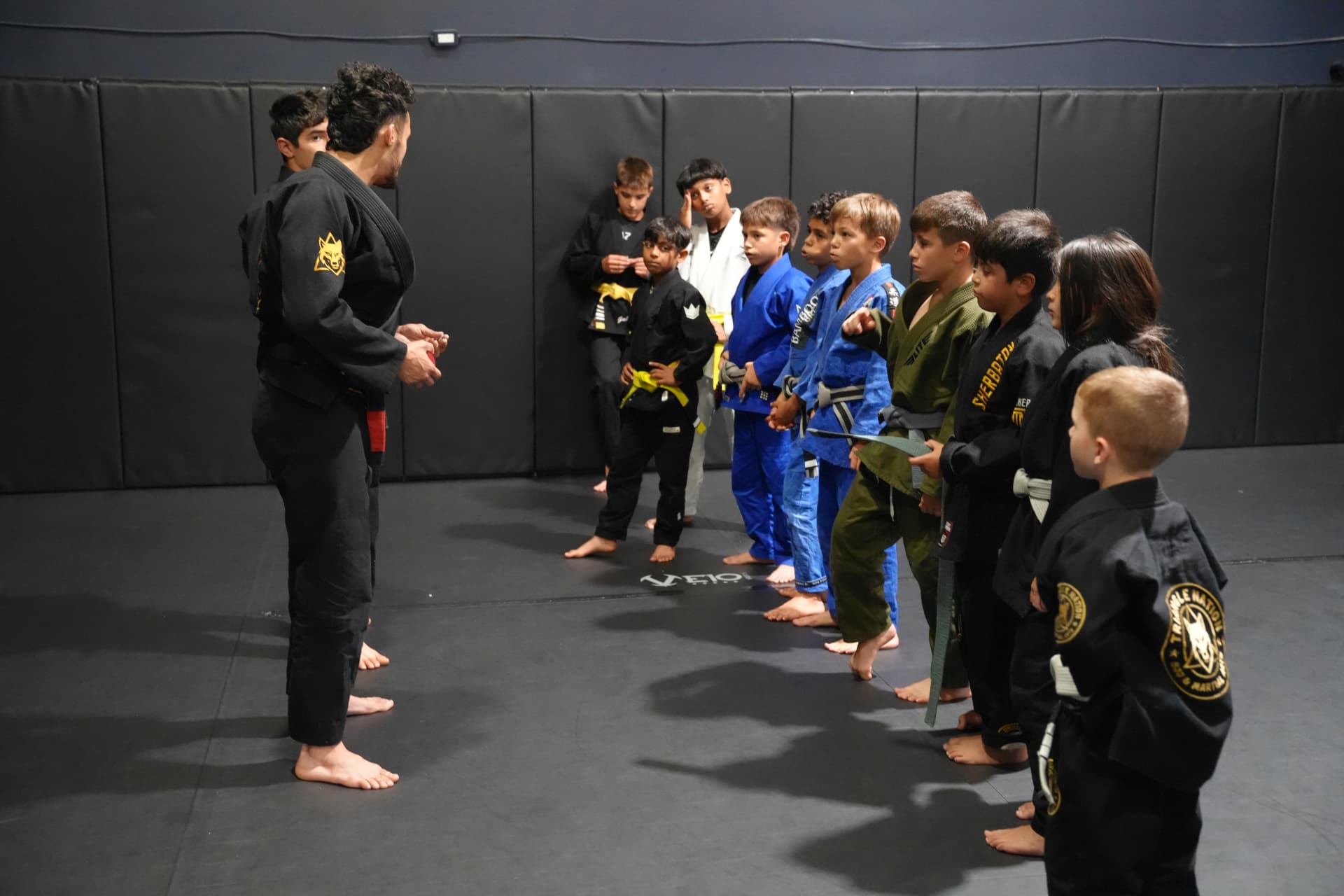 Kids lined up in front of their coaches during a jiu-jitsu camp at Triangle Nation in Laval