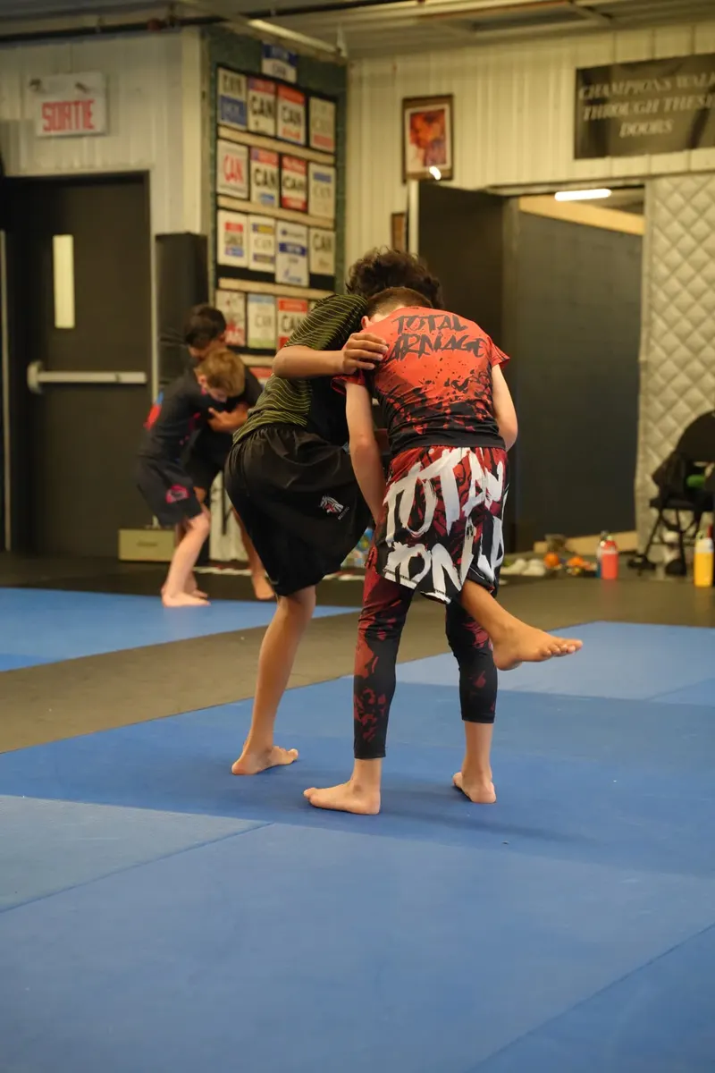 Kids drilling a body lock takedown during competition training