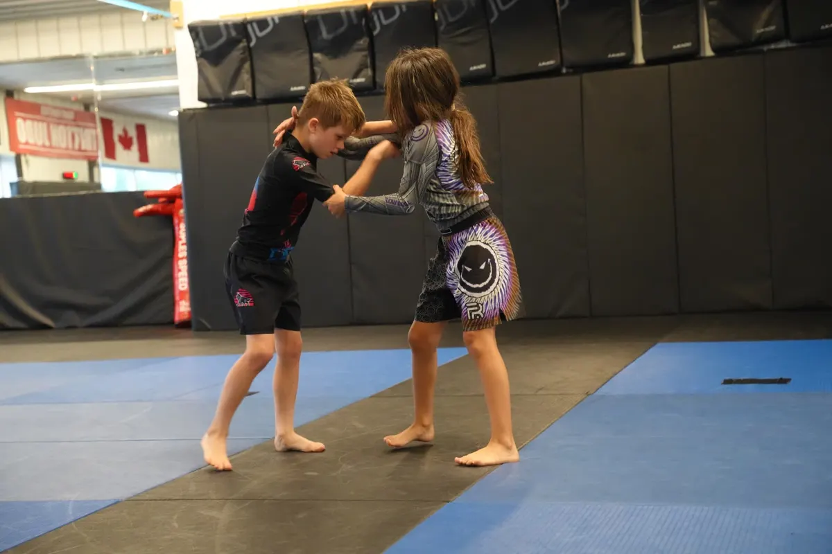 Boy and girl grip fighting in a stance battle